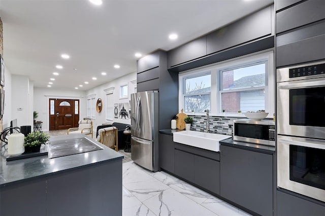 kitchen featuring tasteful backsplash, appliances with stainless steel finishes, sink, and plenty of natural light