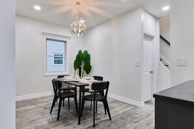 dining space featuring an inviting chandelier and light hardwood / wood-style floors