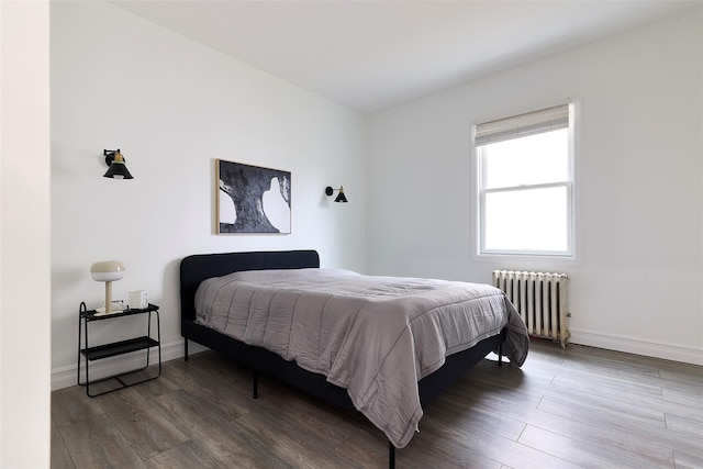 bedroom featuring radiator heating unit and wood-type flooring