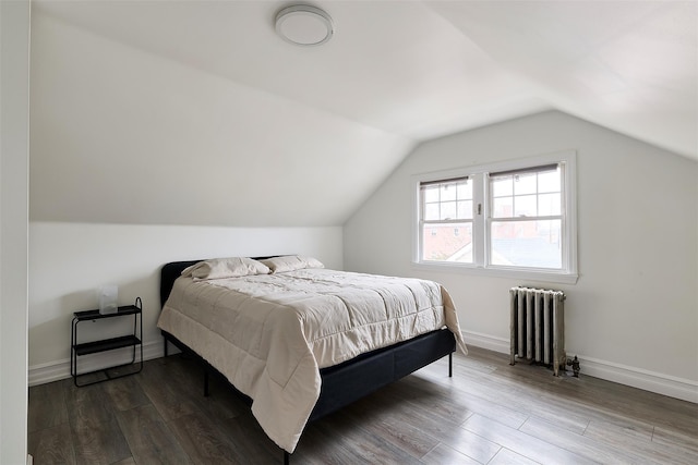 bedroom featuring hardwood / wood-style flooring, lofted ceiling, and radiator heating unit