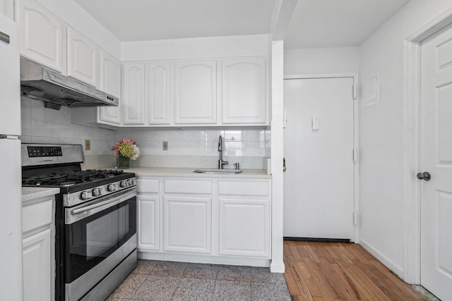 kitchen featuring sink, gas range, tasteful backsplash, light hardwood / wood-style floors, and white cabinets