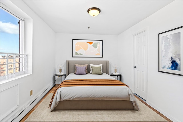 13616 31st Rd Unit 8B, Flushing, NY 11354 - bedroom featuring baseboard heating, multiple windows, wood finished floors, and baseboards