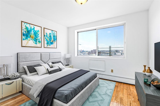 13616 31st Rd Unit 8B, Flushing, NY 11354 - bedroom with a baseboard heating unit and light wood-type flooring