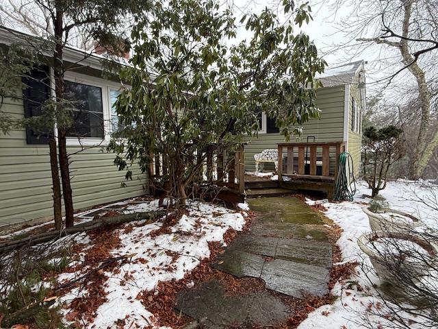 view of snow covered exterior featuring a wooden deck