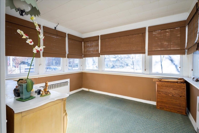 unfurnished sunroom featuring plenty of natural light and radiator