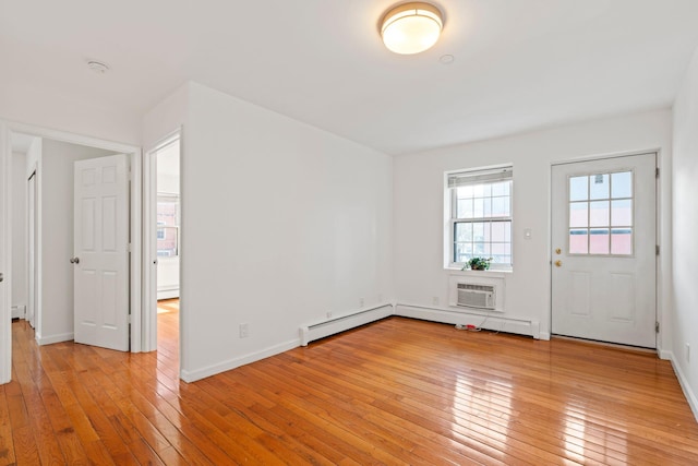 interior space with a wall mounted air conditioner, light hardwood / wood-style floors, and baseboard heating