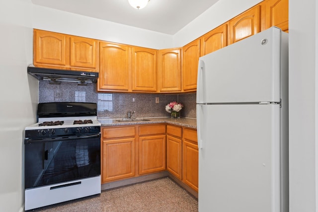 kitchen with sink, white refrigerator, range with gas stovetop, decorative backsplash, and exhaust hood