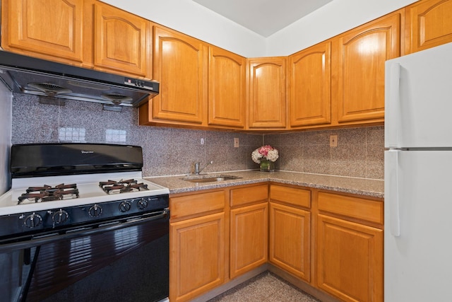 kitchen with range with gas stovetop, sink, decorative backsplash, white fridge, and light stone countertops