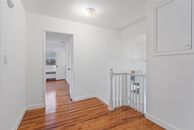 hallway featuring radiator heating unit and wood-type flooring