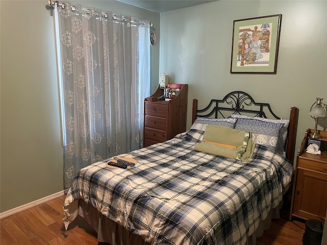 bedroom featuring baseboards and wood finished floors