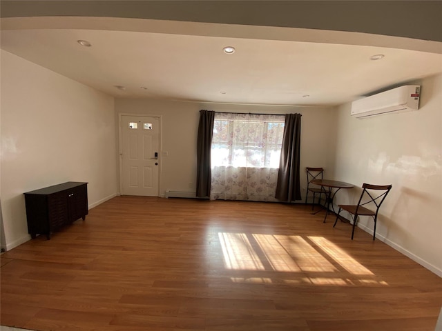 foyer featuring hardwood / wood-style floors and an AC wall unit