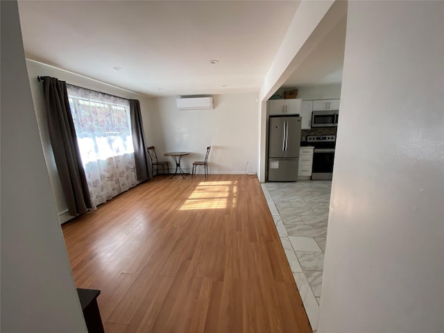 interior space featuring light hardwood / wood-style flooring and an AC wall unit