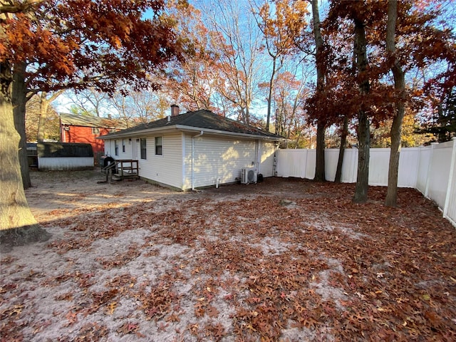 view of property exterior with central AC unit and a storage unit