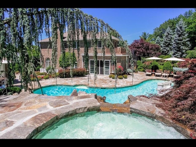 view of pool with an in ground hot tub and a patio