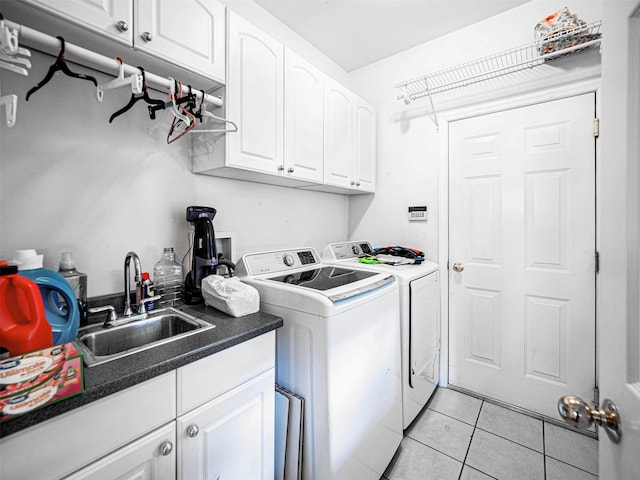 washroom with sink, cabinets, washing machine and clothes dryer, and light tile patterned flooring