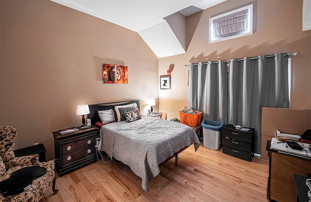 bedroom with lofted ceiling and light hardwood / wood-style floors