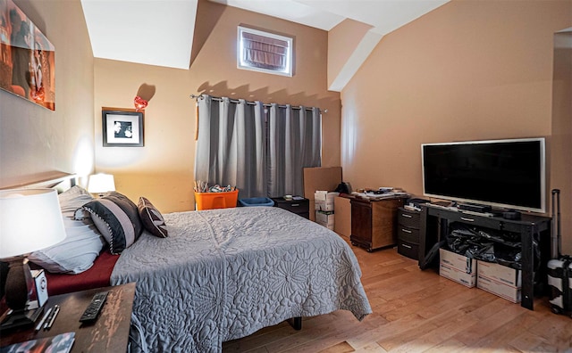 bedroom with a towering ceiling and light hardwood / wood-style floors