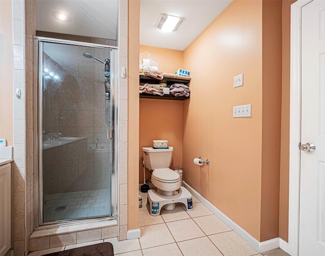 bathroom with tile patterned floors, toilet, and a shower with door