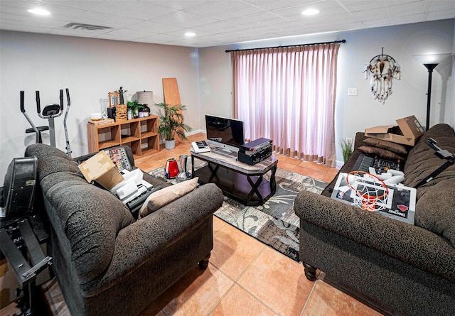 tiled living room featuring a drop ceiling