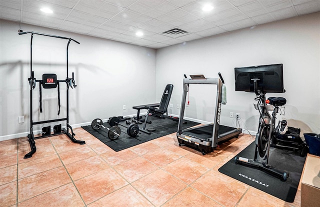 workout room featuring tile patterned flooring and a drop ceiling