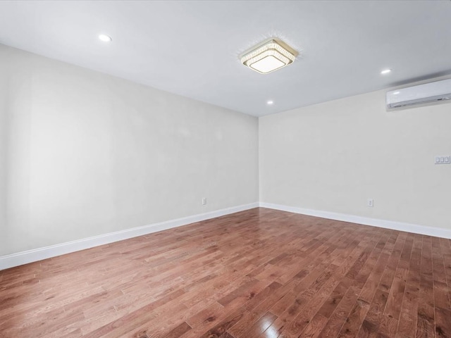 empty room with hardwood / wood-style flooring and a wall mounted AC