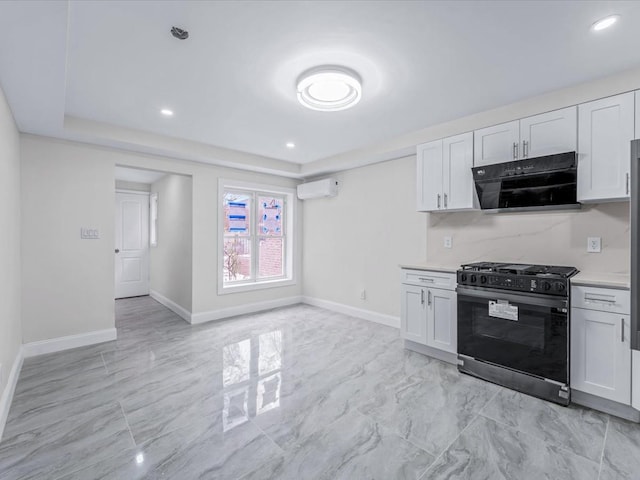 kitchen with black gas range oven, a wall mounted AC, and white cabinets