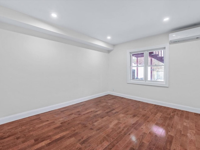 spare room featuring dark hardwood / wood-style floors and an AC wall unit