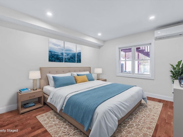 bedroom featuring dark hardwood / wood-style flooring and an AC wall unit