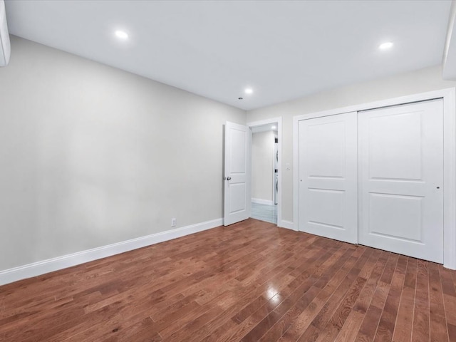 unfurnished bedroom featuring dark wood-type flooring and a closet