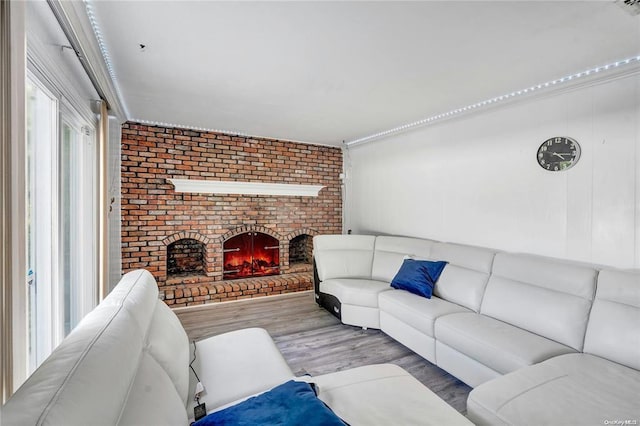 living room with wood-type flooring and a brick fireplace