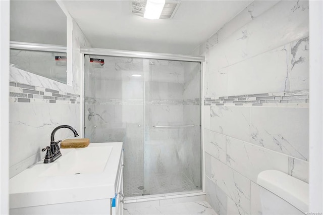 bathroom featuring vanity, tile walls, toilet, and walk in shower