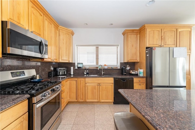 kitchen with sink, decorative backsplash, dark stone counters, and appliances with stainless steel finishes