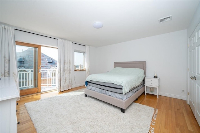 bedroom with wood-type flooring and access to outside