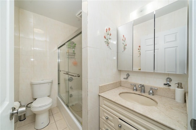 bathroom featuring tile patterned floors, an enclosed shower, tile walls, and vanity