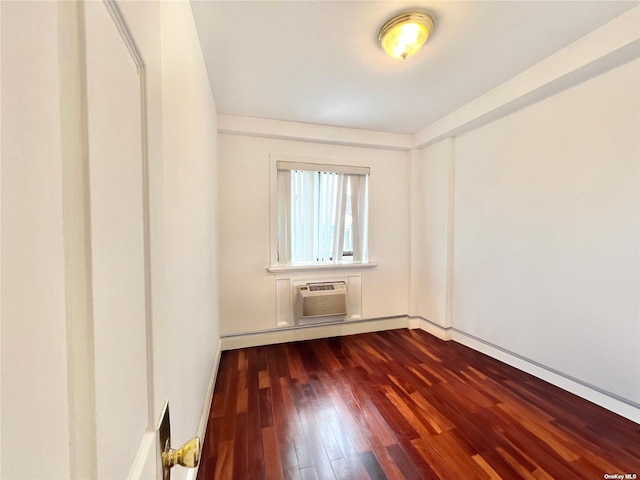 spare room featuring a wall mounted air conditioner, a baseboard radiator, and dark hardwood / wood-style floors