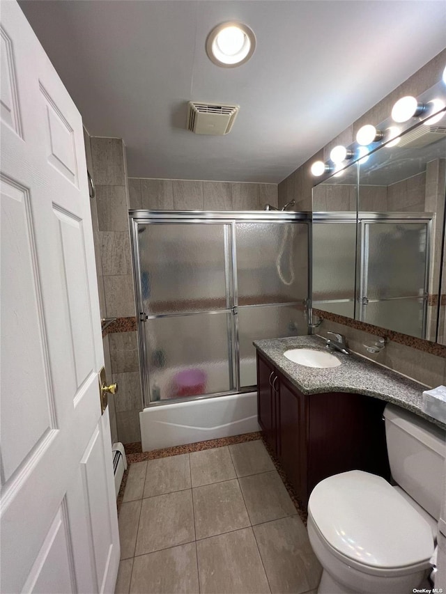 full bathroom with combined bath / shower with glass door, tile patterned flooring, vanity, baseboard heating, and toilet