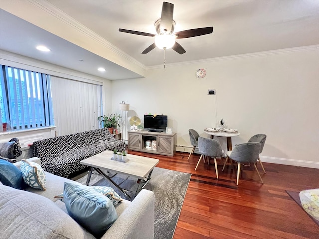 living area with baseboards, a ceiling fan, ornamental molding, wood finished floors, and a baseboard heating unit