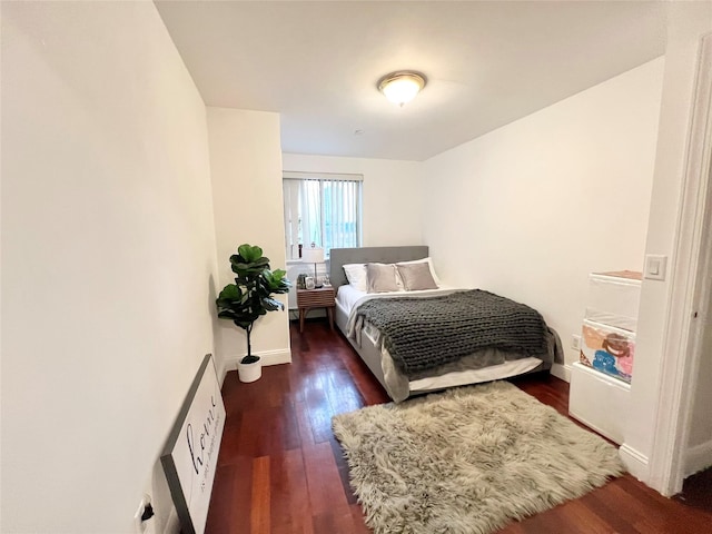 bedroom with baseboards and wood finished floors