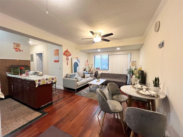 living area with ornamental molding, dark wood-style flooring, and ceiling fan