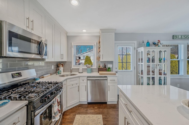 kitchen featuring tasteful backsplash, sink, stainless steel appliances, and white cabinets