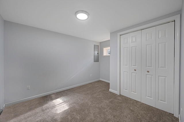 unfurnished bedroom with carpet floors, electric panel, and a closet