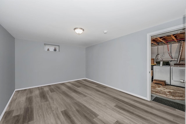 interior space with washing machine and clothes dryer and light hardwood / wood-style flooring