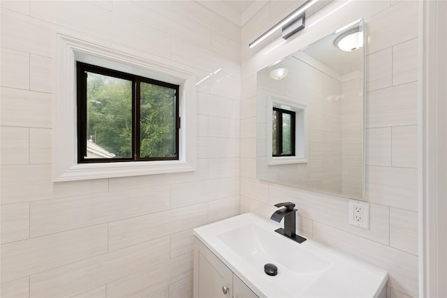 bathroom featuring vanity and tile walls