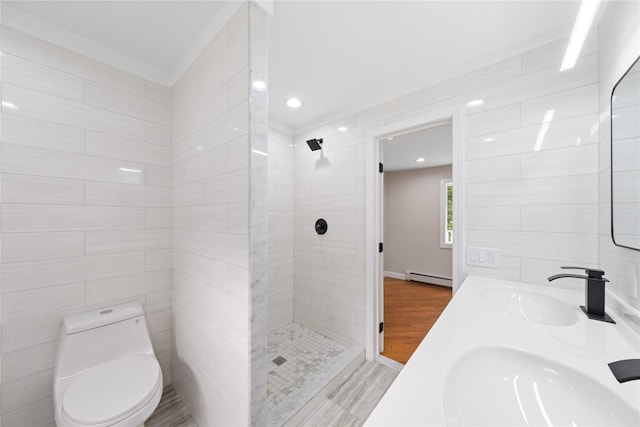 bathroom with a tile shower, a baseboard radiator, tile walls, vanity, and toilet