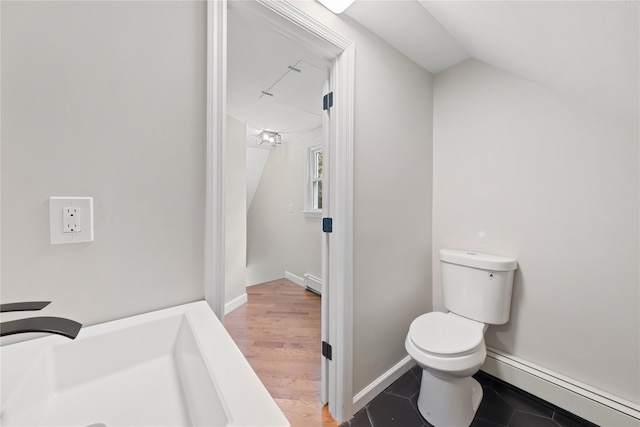 bathroom featuring baseboard heating, lofted ceiling, toilet, and hardwood / wood-style flooring