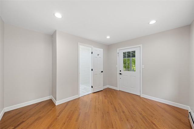 interior space featuring baseboard heating and light hardwood / wood-style flooring