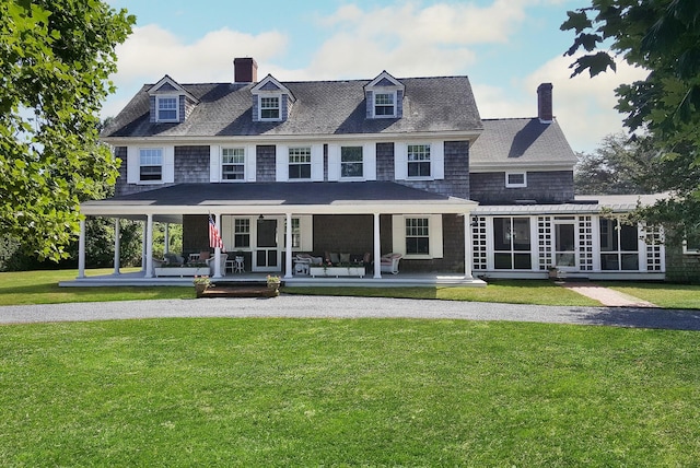 back of property with a lawn, a sunroom, and a porch