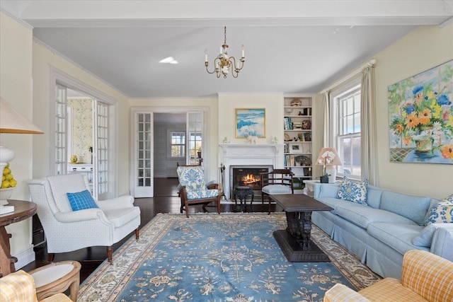 living room featuring crown molding, wood-type flooring, and a notable chandelier