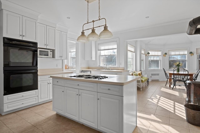 kitchen featuring radiator, white cabinets, hanging light fixtures, crown molding, and white appliances