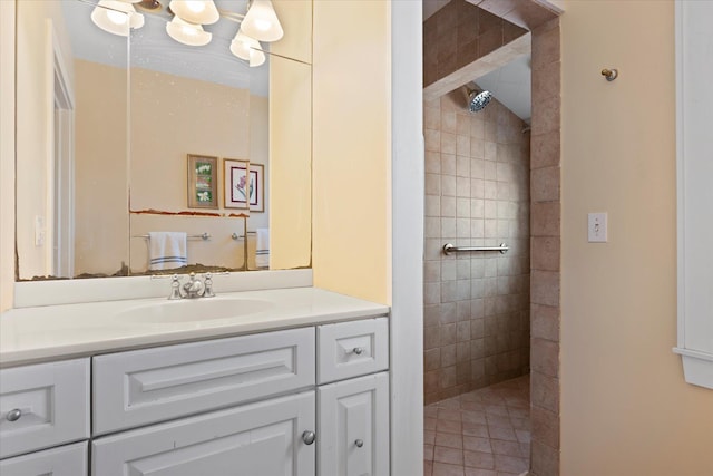 bathroom featuring vanity, an inviting chandelier, and a tile shower